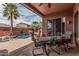 Outdoor covered patio with a dining area, a pool, and lush tropical landscaping at 13146 S 178Th Ave, Goodyear, AZ 85338