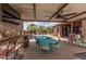 Inviting covered patio area featuring a TV, bar, and dining set adjacent to a sparkling pool at 13146 S 178Th Ave, Goodyear, AZ 85338