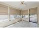 Bright sunroom featuring neutral colors, tiled floors, multiple windows and a ceiling fan at 1356 N Los Altos Dr, Chandler, AZ 85224