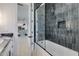 Bathroom featuring a tiled shower-tub combo, gray wall tiles, and modern hardware at 1602 E Cloud Rd, Phoenix, AZ 85086