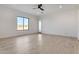 A simple bedroom with wood floors, a ceiling fan, and a large window showing desert scenery at 1602 E Cloud Rd, Phoenix, AZ 85086
