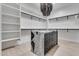 Bright walk-in closet with custom shelving, an island, and a unique chandelier at 1602 E Cloud Rd, Phoenix, AZ 85086