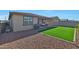 A well maintained backyard featuring artificial grass and a built-in outdoor grill and seating area at 17286 W Running Deer Trl, Surprise, AZ 85387
