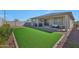 Expansive backyard featuring artificial turf, a covered patio, and well-maintained landscaping, ideal for outdoor living at 17286 W Running Deer Trl, Surprise, AZ 85387