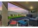 A relaxing covered patio featuring a complete seating set and a flat screen TV at 17286 W Running Deer Trl, Surprise, AZ 85387