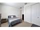 Cozy bedroom with neutral carpet, a comfortable bed, and ample closet space behind sliding doors, creating a serene retreat at 17286 W Running Deer Trl, Surprise, AZ 85387