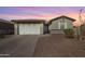 A clean exterior view of single-story home with desert landscaping and a paved driveway at 17286 W Running Deer Trl, Surprise, AZ 85387