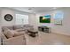 Cozy living room with neutral decor, tiled flooring, and large windows for natural light at 17286 W Running Deer Trl, Surprise, AZ 85387