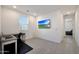 Well-lit office space with neutral tile flooring, a large window, and a mounted television for a modern work environment at 17286 W Running Deer Trl, Surprise, AZ 85387