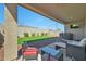 Inviting outdoor patio with stylish furniture, a cozy fire pit, and a view of the well-maintained artificial lawn at 17286 W Running Deer Trl, Surprise, AZ 85387