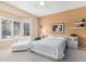 Bright bedroom with natural light, neutral colors, and a cozy chair near the shuttered window at 18014 N Calypso Ct, Surprise, AZ 85374