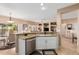 Open-concept kitchen with a breakfast bar, stainless steel appliances, and views of the dining and living areas at 18014 N Calypso Ct, Surprise, AZ 85374