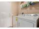 Functional laundry area featuring a modern washer and dryer, plus storage shelving at 18014 N Calypso Ct, Surprise, AZ 85374