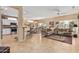 Open-concept living room with tile floors, neutral-toned furniture, and a view of the kitchen and dining area at 18014 N Calypso Ct, Surprise, AZ 85374