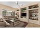 Comfortable living room with large windows, a ceiling fan, and custom shelving at 18014 N Calypso Ct, Surprise, AZ 85374