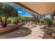 Inviting covered patio with a dining set, lounge chairs, and lush landscaping at 18014 N Calypso Ct, Surprise, AZ 85374
