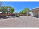 Low-maintenance backyard featuring a gravel landscape, mature trees, and a covered patio area at 1825 E Sycamore Rd, Casa Grande, AZ 85122