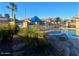 Resort style community pool with inviting chaise lounges, umbrellas, palm trees, and desert landscaping at 1825 E Sycamore Rd, Casa Grande, AZ 85122