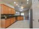 Open kitchen with wooden cabinetry, stainless steel appliances, and views into the living area at 1825 E Sycamore Rd, Casa Grande, AZ 85122