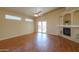 Open living area with fireplace, ceiling fan, hardwood floors, and sliding glass doors with backyard views at 1825 E Sycamore Rd, Casa Grande, AZ 85122