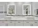 Modern bathroom featuring double sinks, illuminated mirrors, and stylish white cabinets at 18665 N 70Th Dr, Glendale, AZ 85308