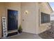 A stylish navy blue front door enhances the curb appeal of this inviting home with desert landscaping at 18665 N 70Th Dr, Glendale, AZ 85308