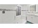 Bright bathroom boasts a glass-enclosed shower, white tile, and a mosaic accent stripe at 18665 N 70Th Dr, Glendale, AZ 85308
