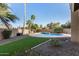 Landscaped backyard features an inground pool with rock waterfall, grass area, and desert landscaping for easy maintenance at 21 W Pecan Pl, Tempe, AZ 85284