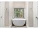 Bright bathroom featuring a stand-alone soaking tub with a large window at 21 W Pecan Pl, Tempe, AZ 85284
