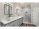 Bright bathroom featuring double sinks, a glass shower and white cabinets at 21 W Pecan Pl, Tempe, AZ 85284