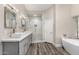 Bright bathroom featuring double sinks, a glass shower and stand-alone soaking tub at 21 W Pecan Pl, Tempe, AZ 85284