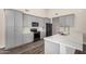 Stylish kitchen featuring gray cabinets, black appliances, quartz countertops, and wood flooring at 21 W Pecan Pl, Tempe, AZ 85284