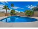 A bright blue swimming pool is surrounded by palm trees and a built-in grill area with plenty of shade at 21 W Pecan Pl, Tempe, AZ 85284