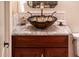 Bathroom vanity featuring a decorative glass bowl sink, bronze faucet, and dark wood cabinets at 23116 N Del Monte Dr, Sun City West, AZ 85375