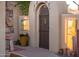 Charming courtyard entrance with arched doorway, stone accents, and potted plants at 23116 N Del Monte Dr, Sun City West, AZ 85375