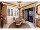 Dining room features a round table, chandelier, and glass paneled exterior door at 23116 N Del Monte Dr, Sun City West, AZ 85375