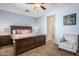 Cozy bedroom featuring a dark wood bed frame, neutral walls, and a comfortable reading chair at 2524 E Katrina Trl, Casa Grande, AZ 85194