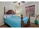 Bedroom with a four-poster bed, soft blue bedding, a dark wood frame, and natural light from the window at 2524 E Katrina Trl, Casa Grande, AZ 85194