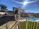 Backyard featuring a sparkling swimming pool, green grass, white metal fencing, and covered patio at 2634 E Fountain St, Mesa, AZ 85213