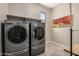Laundry room with stacked washer and dryer plus space for folding and storage at 2753 S 85Th Way, Mesa, AZ 85209