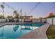 Backyard pool featuring a pergola, basketball hoop, string lights, and a block wall for privacy at 3016 N 49Th St, Phoenix, AZ 85018