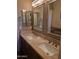 Bathroom featuring a double sink vanity with granite countertops and framed mirrors at 35317 N 31St Dr, Phoenix, AZ 85086