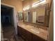 Bathroom featuring a double sink vanity with granite countertops and framed mirrors at 35317 N 31St Dr, Phoenix, AZ 85086