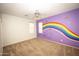 Spacious bedroom with a rainbow mural on one wall and neutral carpet at 35317 N 31St Dr, Phoenix, AZ 85086