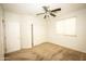 Inviting bedroom with neutral carpet, a ceiling fan, and closet with sliding doors, creating a serene atmosphere at 35317 N 31St Dr, Phoenix, AZ 85086
