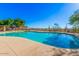 A view of the neighborhood pool. There is desert landscaping surrounding it, and lounge chairs and tables are available at 35317 N 31St Dr, Phoenix, AZ 85086