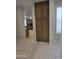 Hallway with a view of a modern kitchen, wood cabinet, and tile floors at 35317 N 31St Dr, Phoenix, AZ 85086