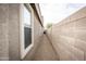 Narrow side yard with gravel featuring views of wall and window at 35317 N 31St Dr, Phoenix, AZ 85086