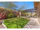 Landscaped backyard featuring a well-maintained lawn, covered patio, and outdoor seating area at 41624 N Anthem Ridge Dr, Anthem, AZ 85086