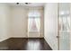 A bright bedroom featuring dark hardwood floors and a large window with blinds at 41624 N Anthem Ridge Dr, Anthem, AZ 85086